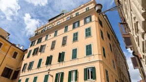 Un immeuble à étages doté d’un style architectural classique, caractérisé par des fenêtres régulièrement espacées et une façade symétrique.