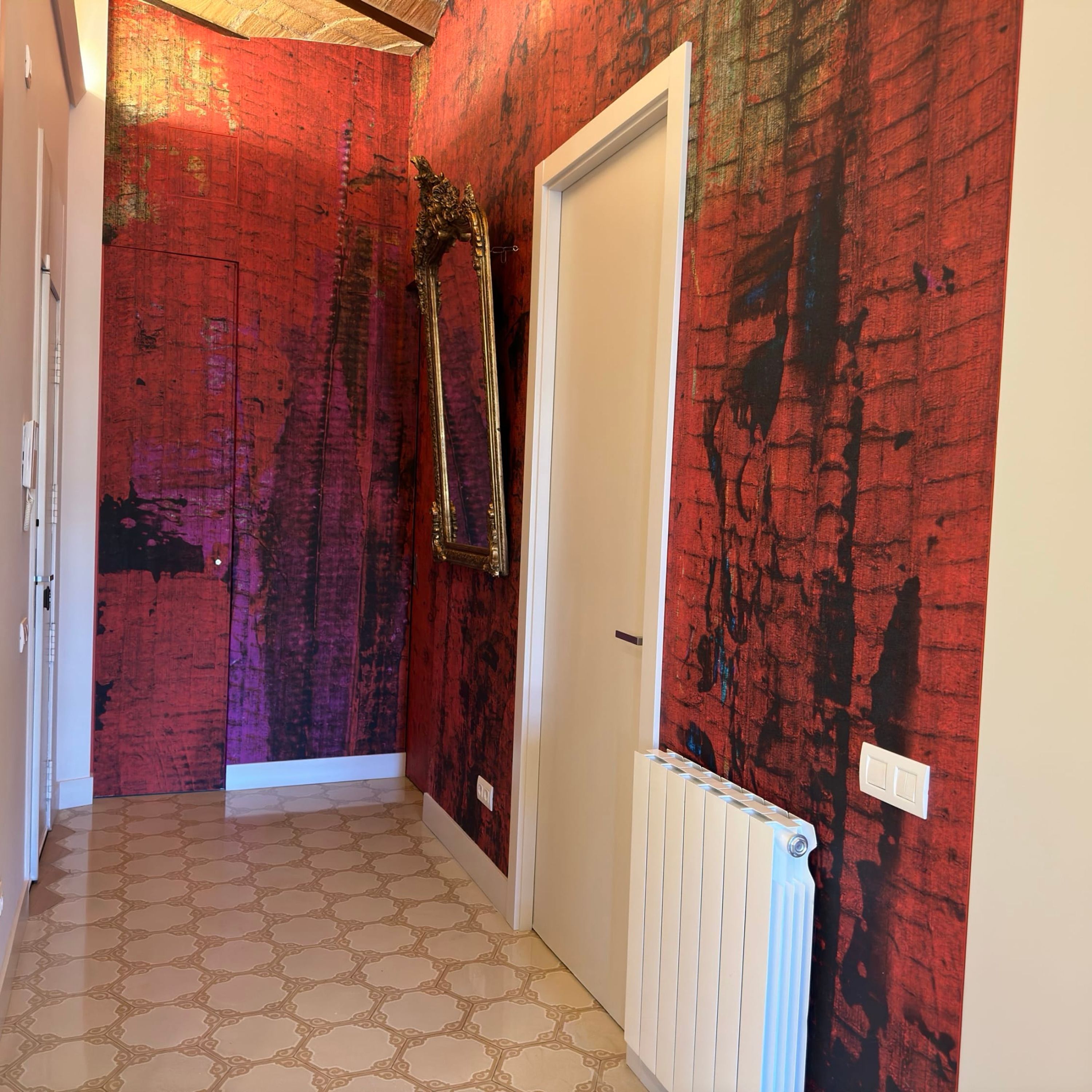 A hallway with a red textured wall, a white door, and a radiator.