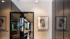 Un intérieur moderne avec un banc, des murs recouverts de miroirs et des œuvres d’art.