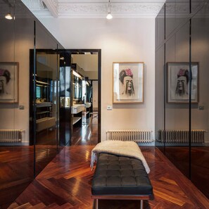 A modern room with a wooden floor, a bench, a radiator, and framed artwork on the walls. - Artist Modernist 3-br Gem Next to Paseo de Gracia (Barcelona)