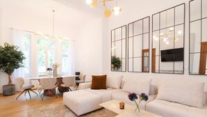 Ein modernes Wohnzimmer mit Sofa, Couchtisch und Essbereich.