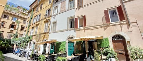 A cobblestone street with outdoor seating and a café.