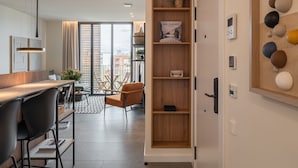 Una cucina moderna con un piano di lavoro in legno e sedie nere, un'area pranzo con tavolo e sedie, e una grande libreria in legno.