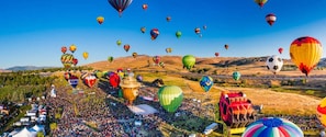 A hot air balloon festival with numerous colorful balloons in the sky and a large crowd on the ground. - Relaxing 2-br Apt With Pool Hot Tub Gym and Basketball Court Access (Reno)