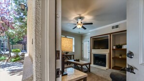 A room with a ceiling fan, a fireplace, a dining table, and a bookshelf. - Marketing in Reno With 2 Bedrooms and 2 Bathrooms (Reno)