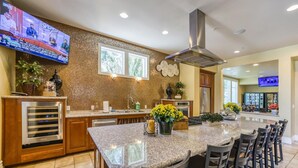 A modern kitchen with a large island, built-in oven, and a TV mounted on the wall. - Marketing in Reno With 2 Bedrooms and 2 Bathrooms (Reno)
