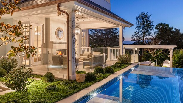 Una casa moderna con piscina, terraza cubierta y zona de estar al aire libre.