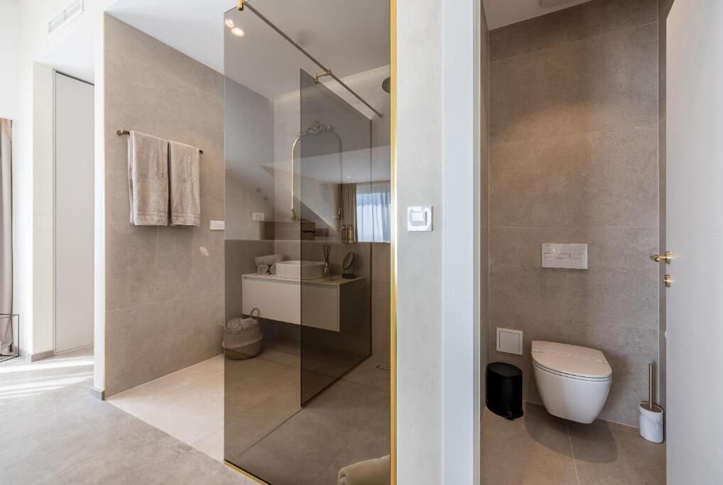 Ein modernes Badezimmer mit Glasdusche, Toilette und Waschbecken.