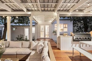Un amplio espacio al aire libre con un sofá, una parrilla y una mesa de comedor.