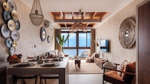 Una sala de estar moderna con comedor, ventanas grandes y vista al océano.