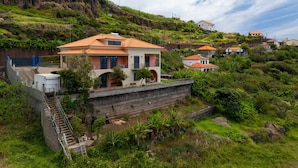 Un quartier résidentiel situé sur une colline, où les maisons se distinguent par leurs toits en tuiles de terre cuite et présentent un mélange d’architecture moderne et traditionnelle.