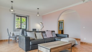 Un salon moderne avec un canapé, une table basse et un coin repas.