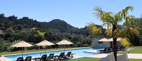Piscine couverte, piscine extérieure, parasols de plage, chaises longues