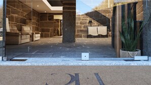 Ein modernes Interieur mit Steinwänden, einem Empfangstisch und einer Zimmerpflanze.
