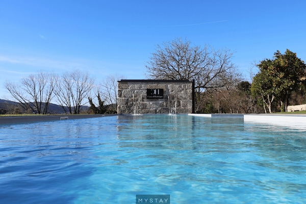 Una piscina techada, una piscina al aire libre, sombrillas