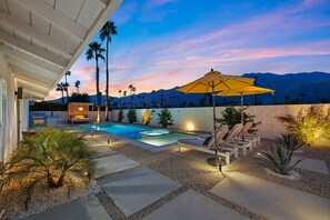 A backyard with a swimming pool, lounge chairs, and a pergola with an umbrella. - Casa del Sol- Modern Paradise w Pool and Casita (Palm Springs)