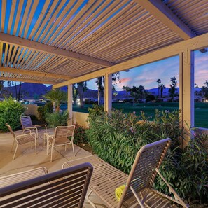 Relax in a serene outdoor space surrounded by lush greenery and a golf course view.