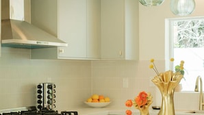 A modern kitchen with a gas stove, stainless steel appliances, a white countertop, and a bowl of oranges. - Mod Hotel in Palm Springs (Palm Springs)