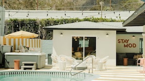 A pool area with a mountain view, a small building with 'STAY MOD' signage, and outdoor seating. - Mod Hotel in Palm Springs (Palm Springs)