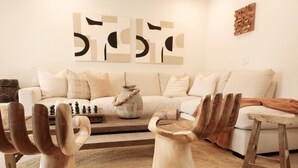 Ein Wohnzimmer mit einer Couch, einem Holztisch und Dekorationselementen.
