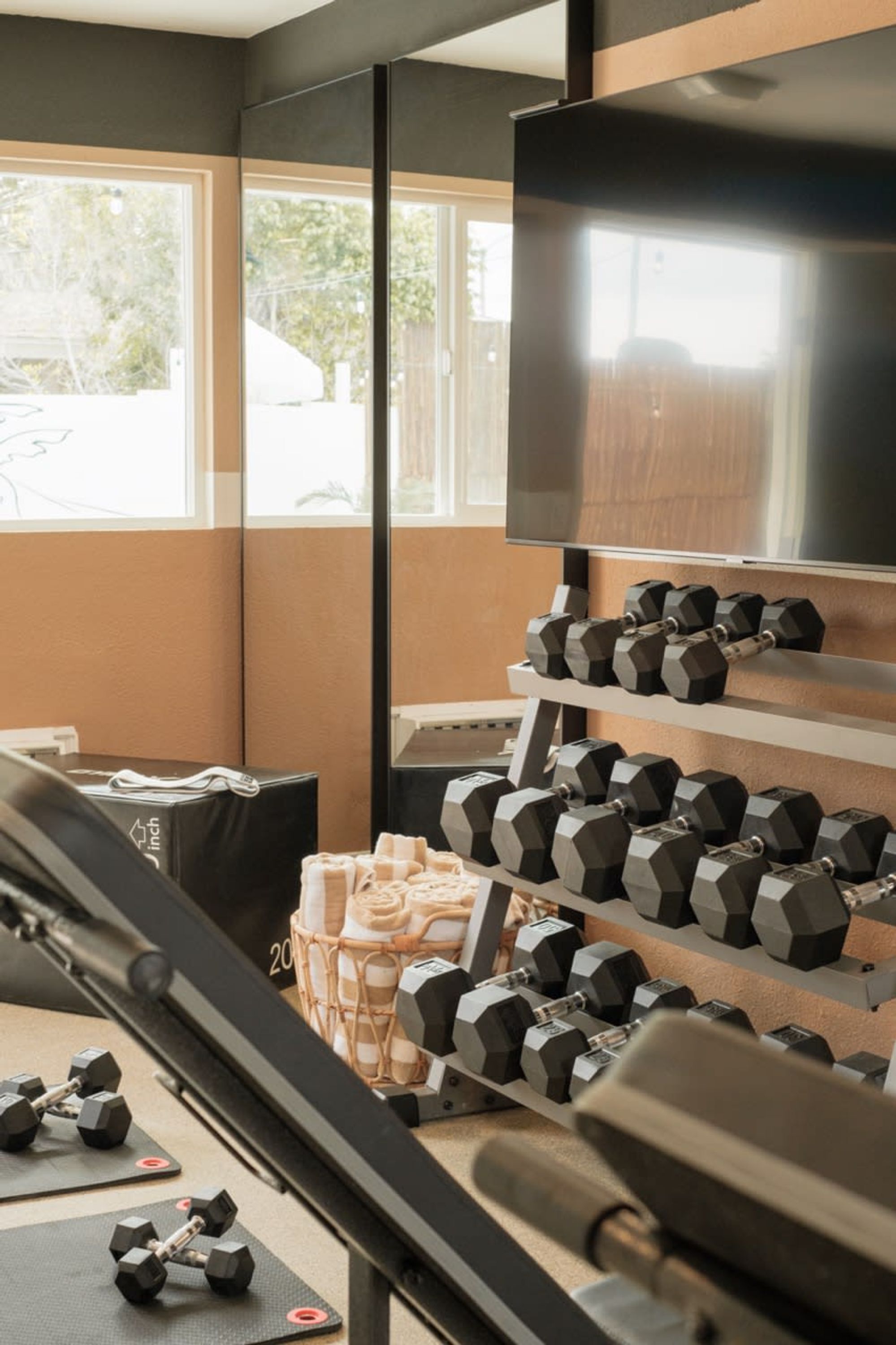 A gym with exercise equipment, including dumbbells and a treadmill.