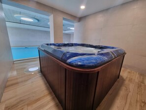 A modern spa area with a hot tub, wooden flooring, and a blue-tiled wall. - Casa la Vista by Bookaparadise (Finestrat)