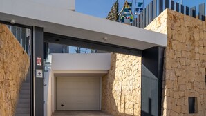 A modern building with a stone facade, a garage door, and a staircase leading to an upper level. - Villa Esmeralda 20 by Bookaparadise (Finestrat)