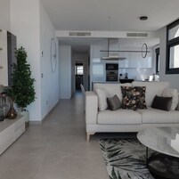 Una sala de estar moderna con un sofá, una mesa de centro y una planta en maceta.