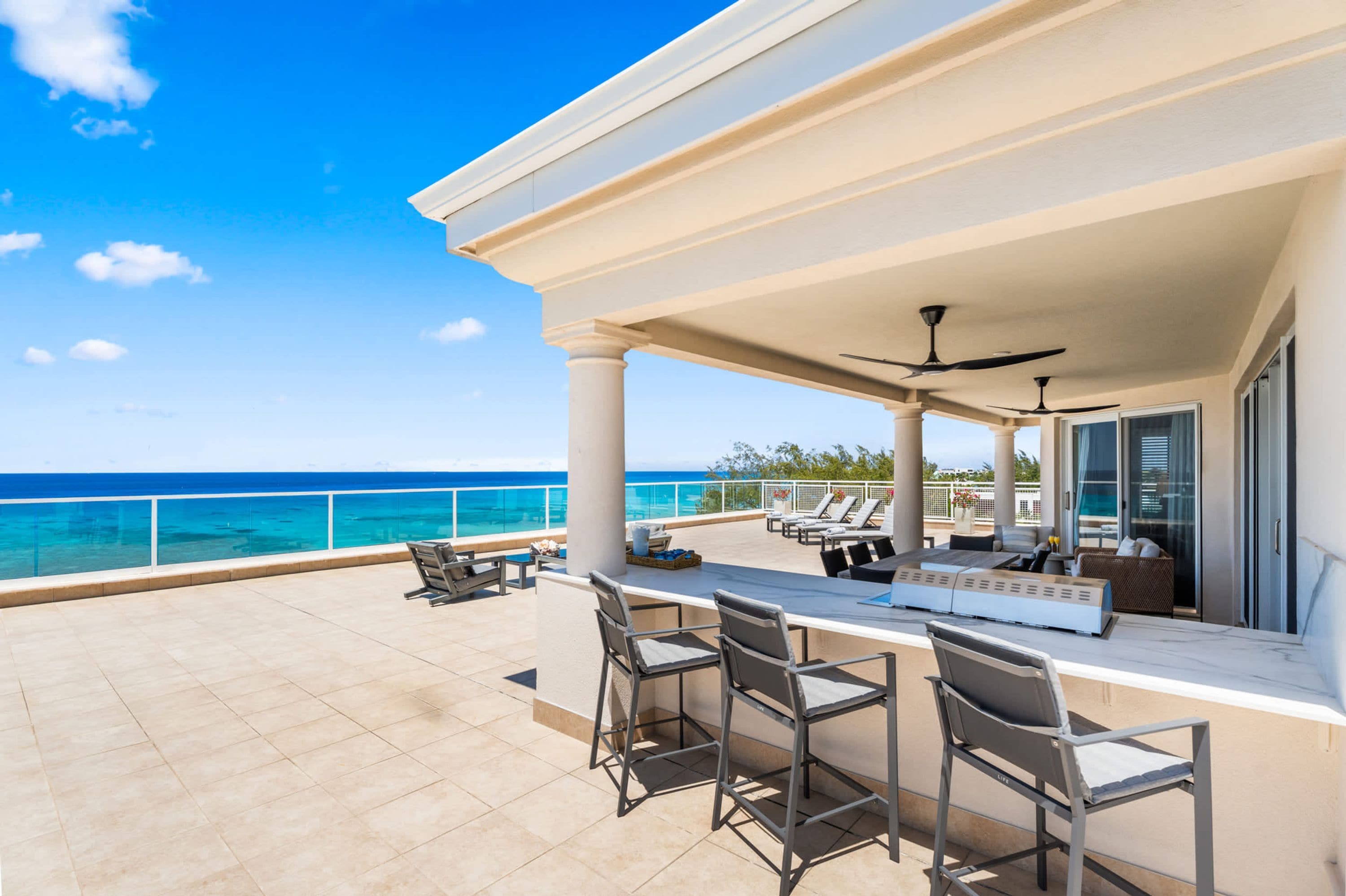 A covered outdoor area with a pool, bar, and seating.