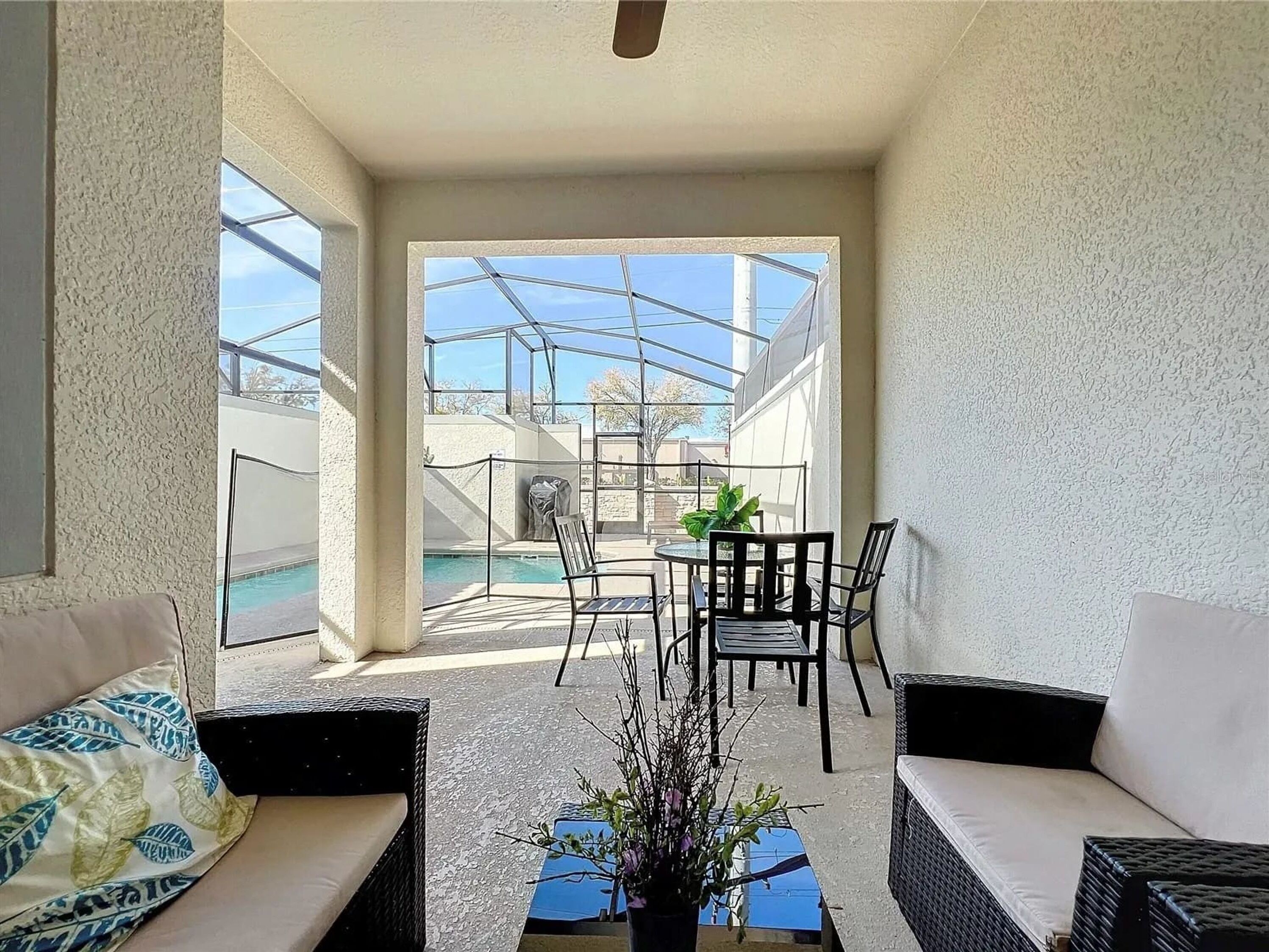 Een balkon met een zwembad, tuinmeubilair en uitzicht op de omgeving.