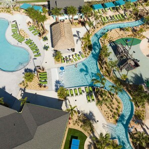 An aerial view of a resort with multiple swimming pools, lounge areas, and palm trees. - 4Bd Close to Disney With Pool at Storey Lake 2560 (Kissimmee)