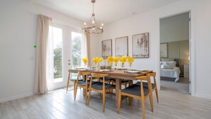 Ein Essbereich mit Holztisch und -stühlen, einer Chandelier und Bildern an den Wänden.