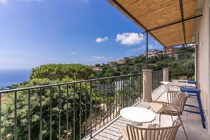 A balcony with a view of the sea and a terrace with outdoor furniture. - Le Arcate Sea La Vie (Massa Lubrense)