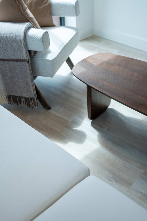Un salon moderne avec un canapé, une table basse et un plancher en bois.