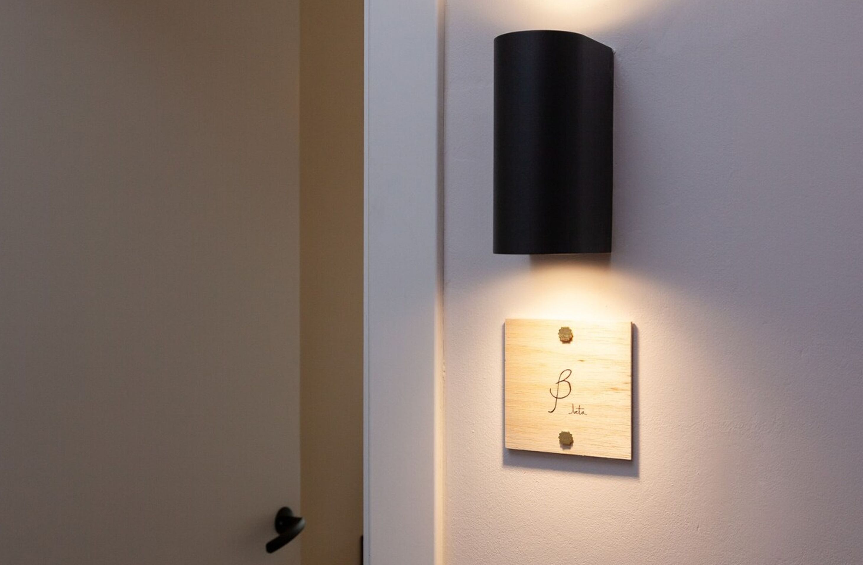 A wall-mounted light fixture with a wooden plaque below it.