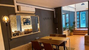 Ein Essbereich mit einem Holztisch, zwei Stühlen, einem großen Spiegel und einer Steinwand.
