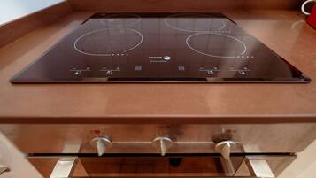 A kitchen with a brown countertop, a Fagor induction cooktop, and a stainless steel oven.