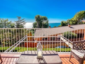 A balcony with a view of the sea, a lantern, and outdoor furniture. - Unik Vacation Tamarit (Tarragona)