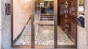 A hotel entrance with a glass door, a nameplate reading "PRATDELAR," and a public notice on the wall. - Unik Vacation Penthouse (Tarragona)