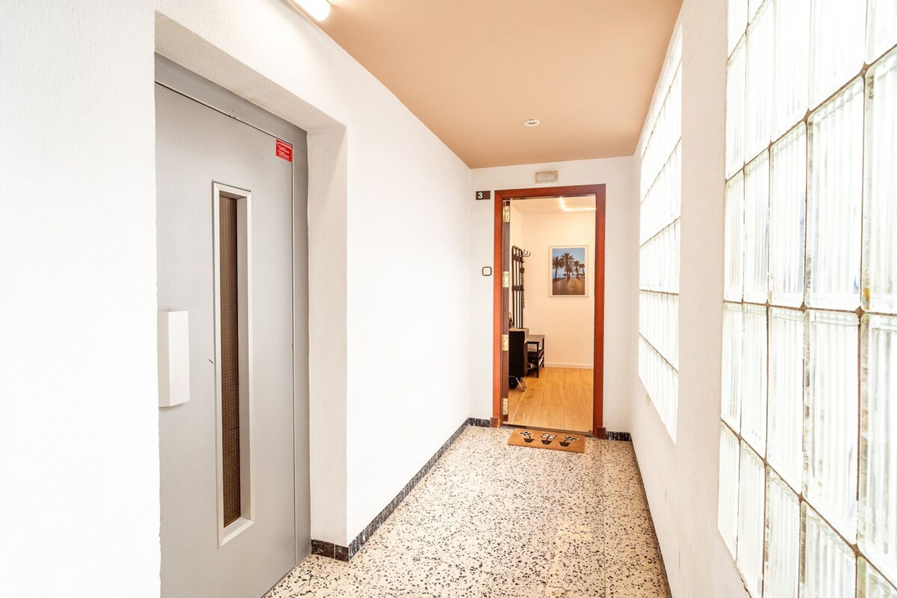 A hallway with a door marked '3', a tiled floor, and a wall with a window.
