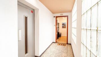 A hallway with a door marked '3', a tiled floor, and a wall with a window.