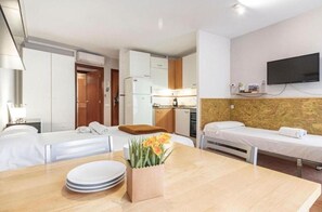 Cozy retreat with a single bed, kitchenette, and flat-screen TV.
