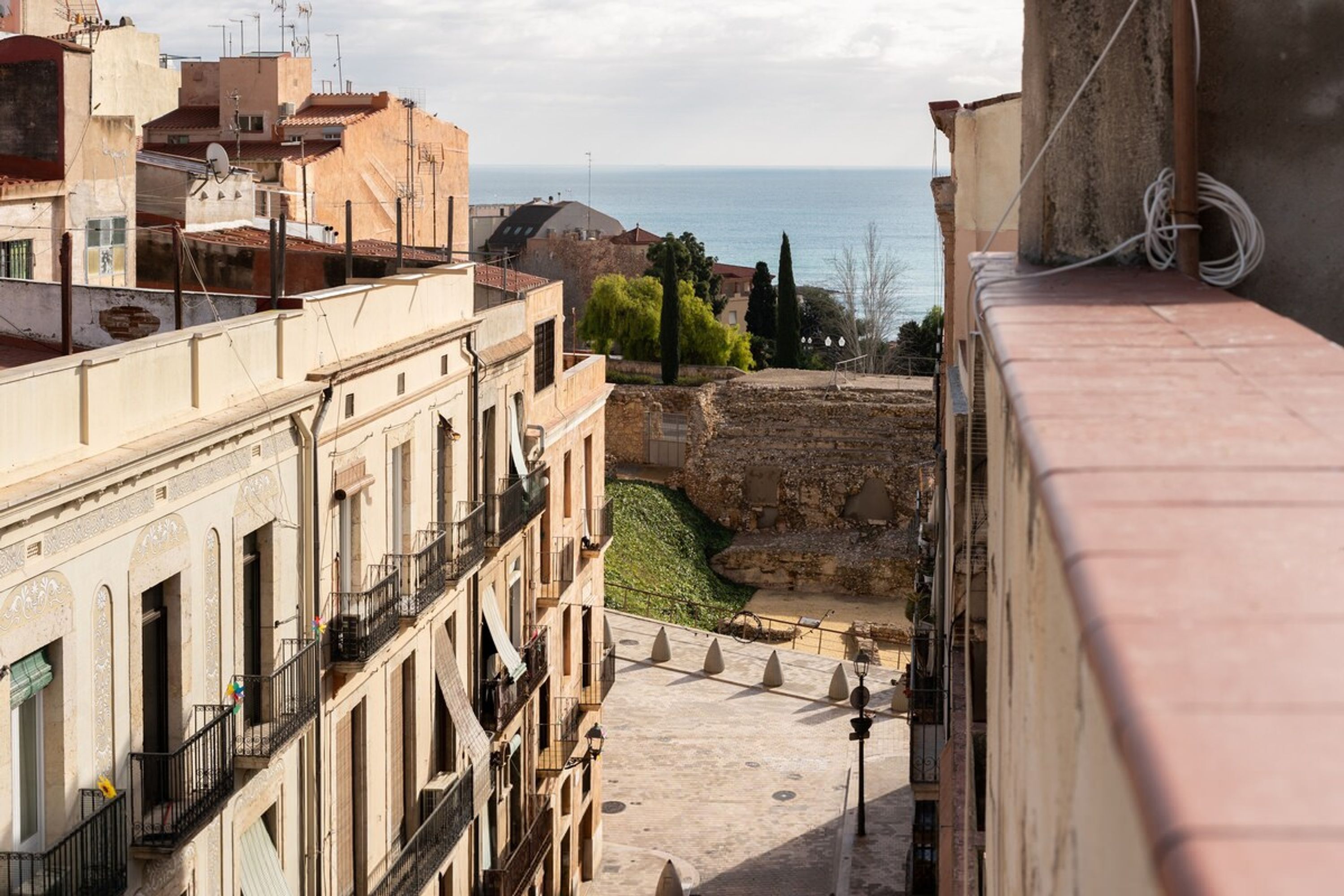A view of a historic cityscape with buildings, a clear sky, and a distant body of water.