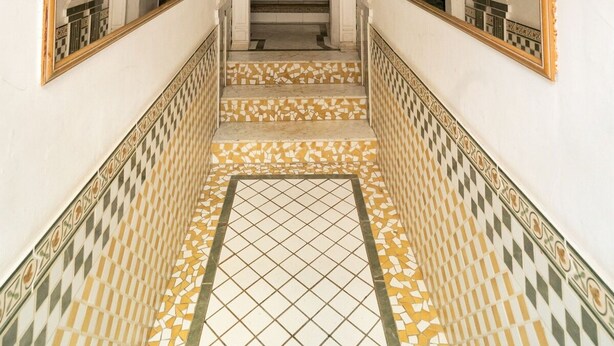 A hallway with a tiled floor, a staircase, and large mirrors on either side. - Unik Vacation C s del Bou (Tarragona)