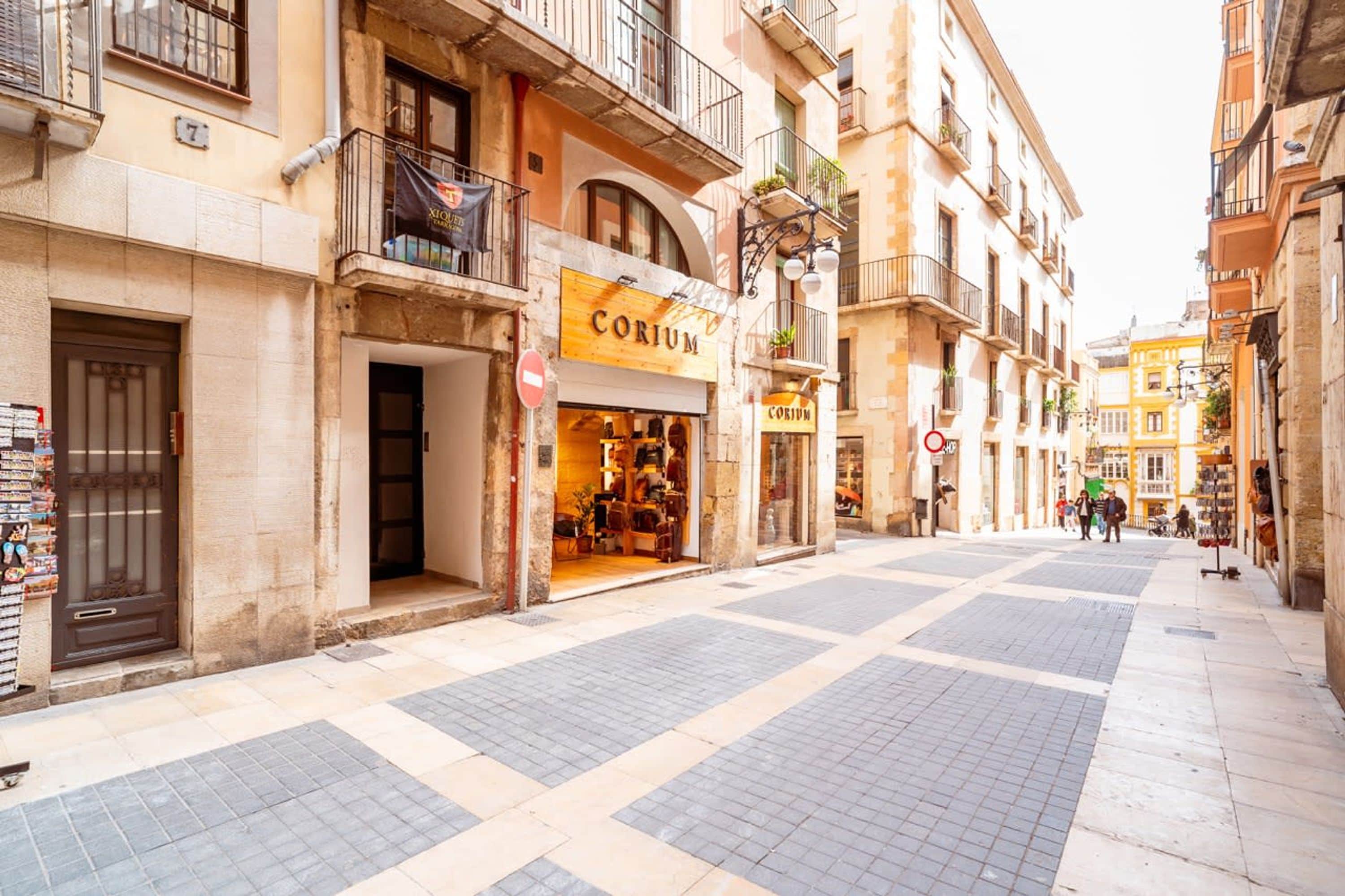 Una calle con una tienda llamada 'CORIUM' en la planta baja.