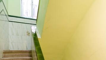 Un escalier avec des marches en marbre et une rampe en verre vert.