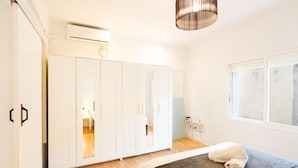 Quarto com cama, guarda-roupa e janela.