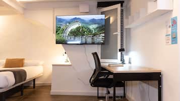 1 habitación, escritorio y tabla de planchar con plancha