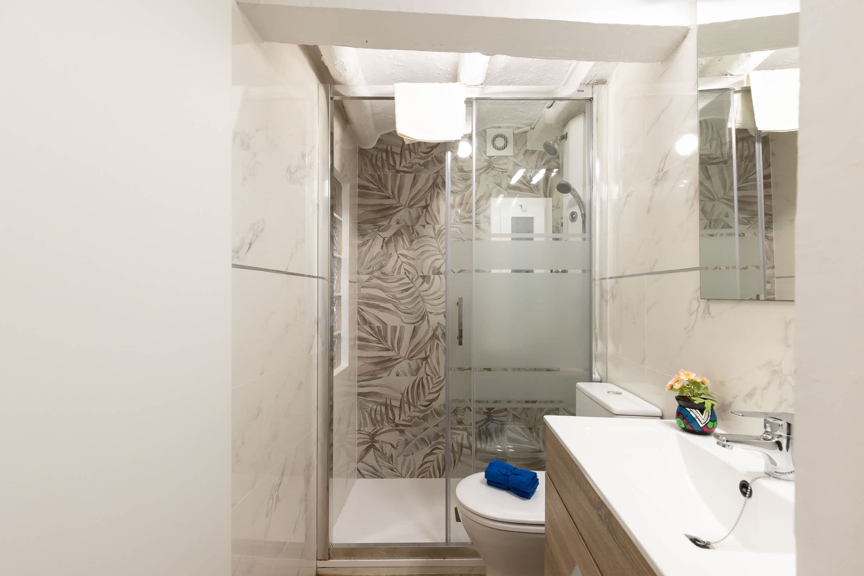 A bathroom with a shower, toilet, and sink.