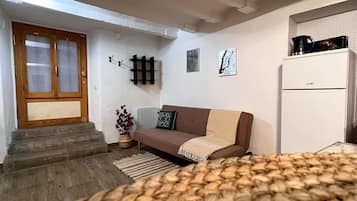 Departamento | 1 habitación, escritorio y tabla de planchar con plancha